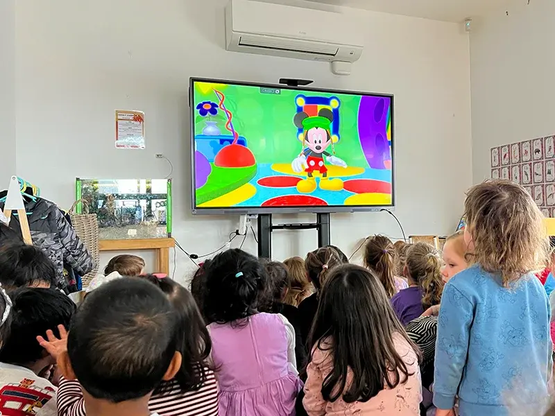 Children sitting in a circle for story time with a qualified early childhood teacher